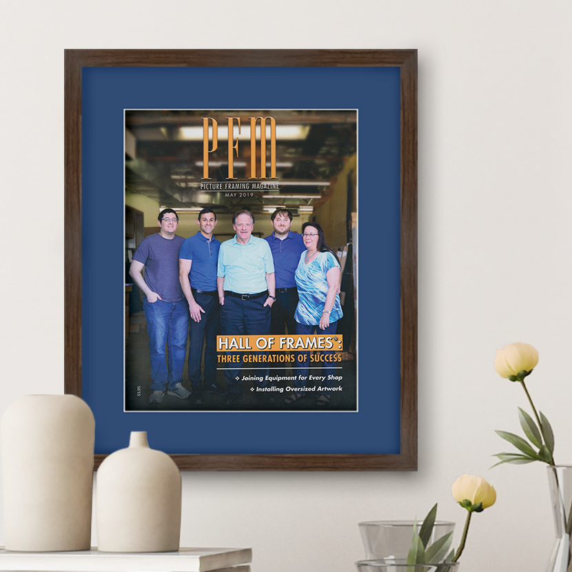 A photo of a custom framed Picture Framing Magazine, featuring Hall of Frames on the front cover.