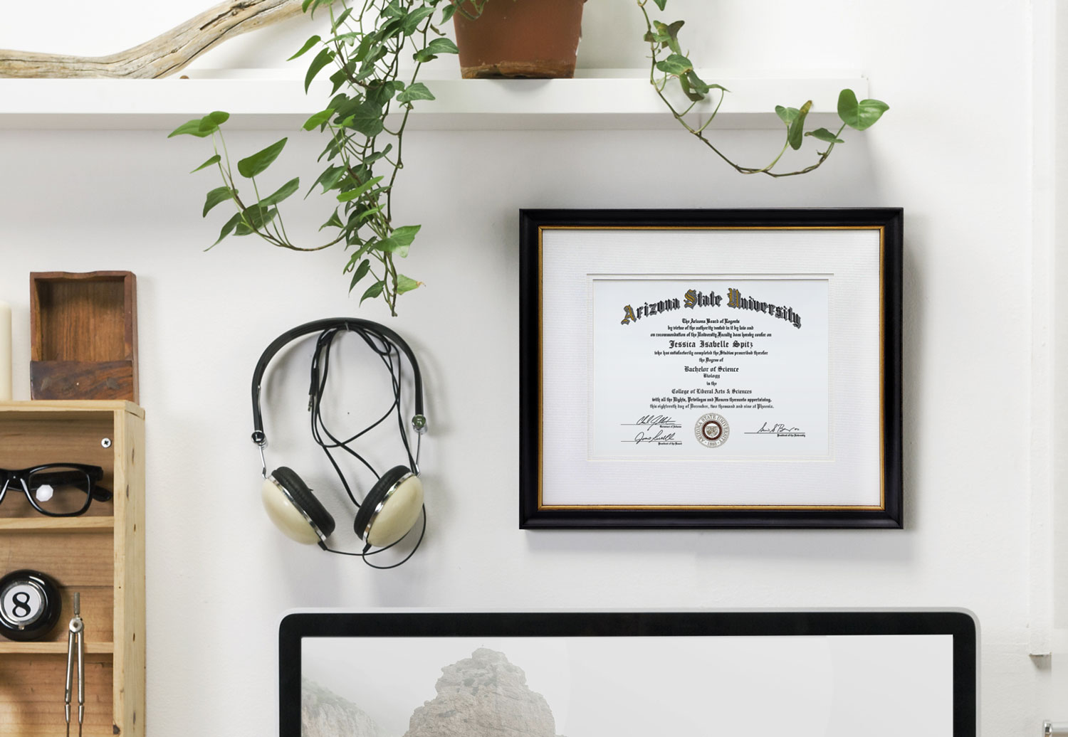 A framed diploma hanging above a desk