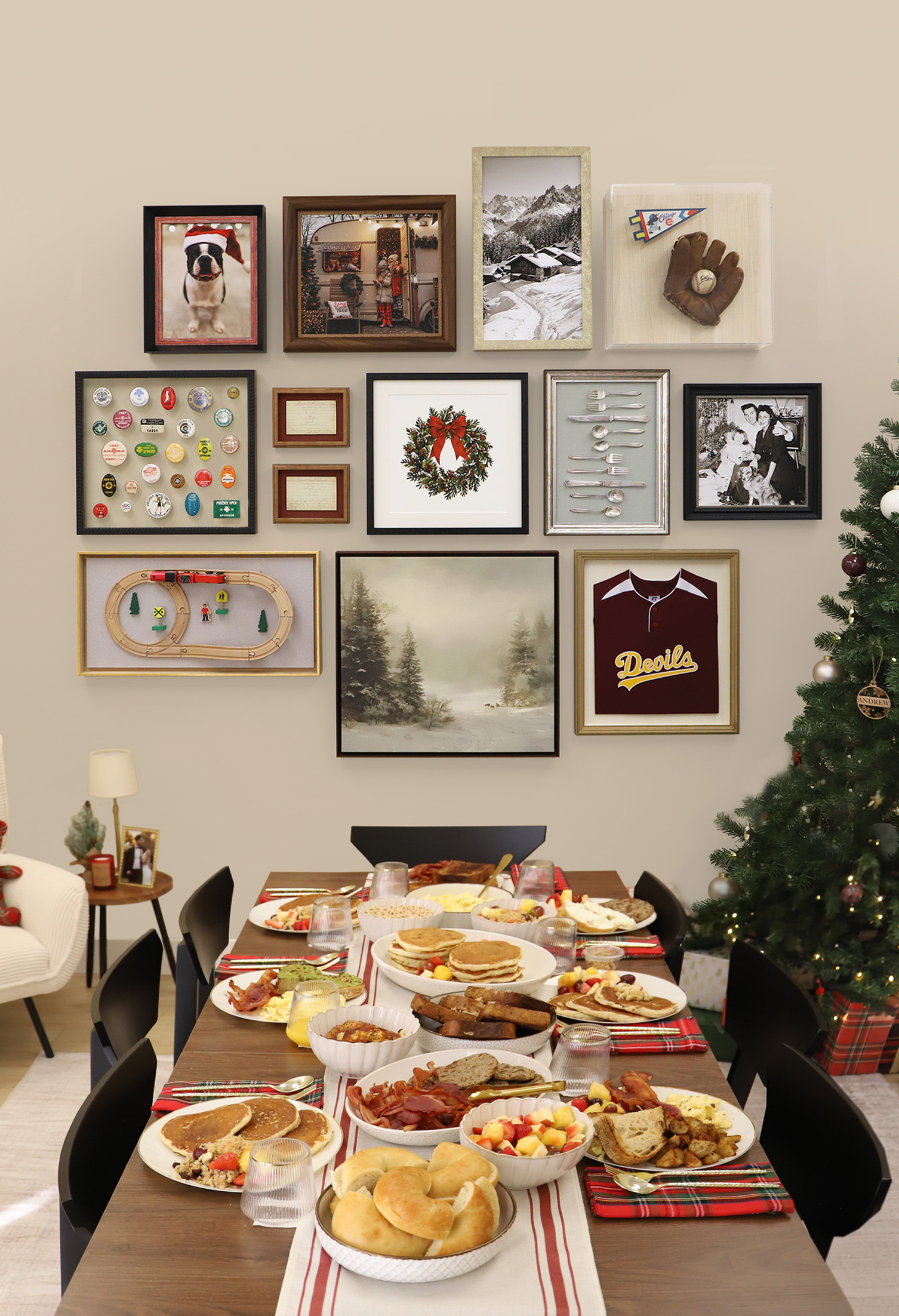 Festive breakfast spread on a dining table next to a Christmas tree, set beneath a custom gallery wall of shadowboxes and framed artwork